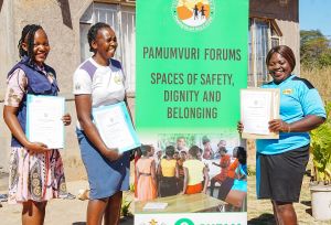 Young women from Zimbabwe holding their certificates