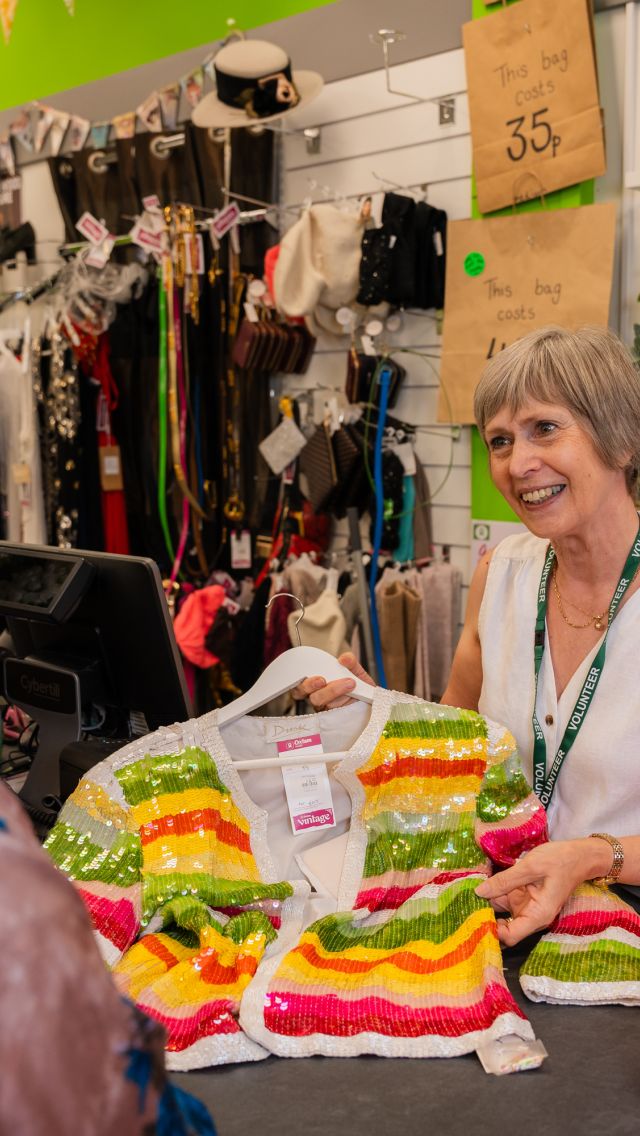 Volunteer in an Oxfam Shop at the till with customer