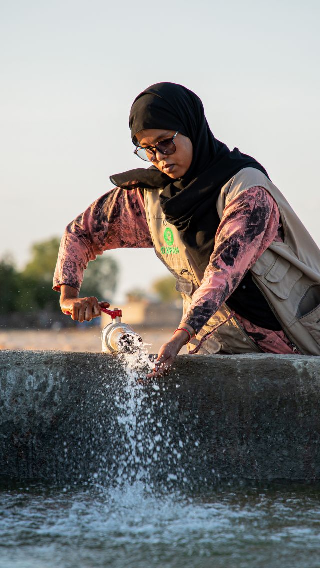 Hodan Warsame, Oxfam water engineer in Somalia helping Boocame, Huftiro District community to fetch water at an Oxfam built water point Sool Region, Northern Somalia