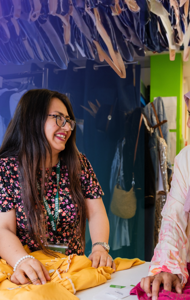 Two volunteers smiling at each other
