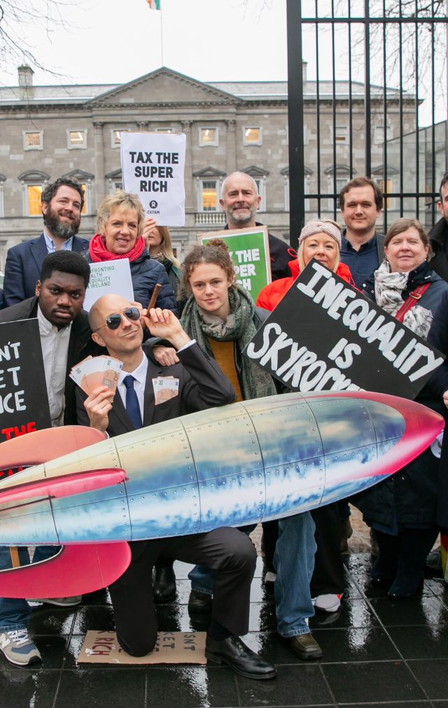 Oxfam Ireland tax the super rich stunt - campaigners, politicians and staff protesting outside Leinster House