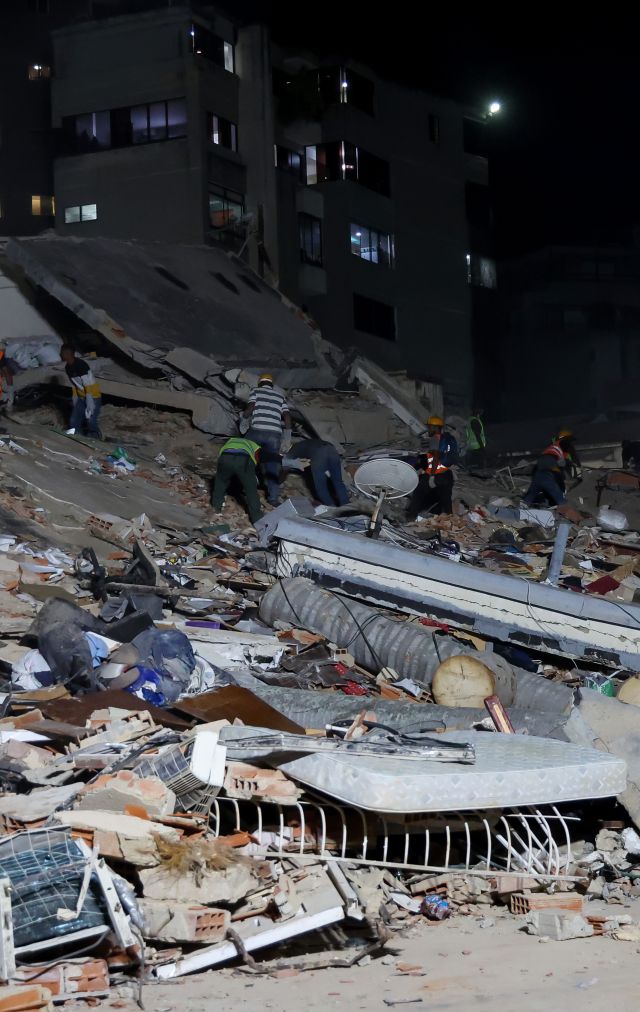 People and rescuers work on the debris from the Rita building after a magnitude 7.2 earthquake struck Venezuela and other regions in the Caribbean 