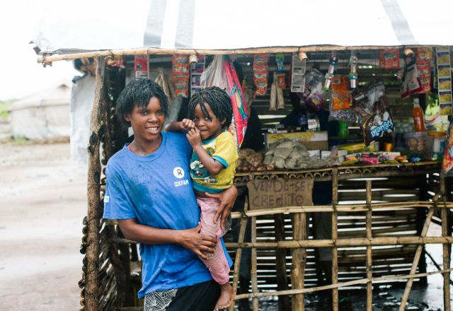 Sonia, and her child in front of her business