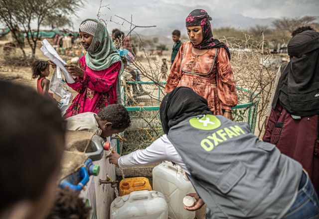 people with jerry cans at a distribution point built by Oxfam