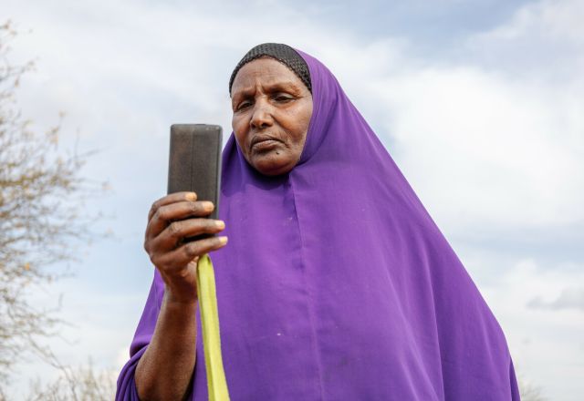 Ebla Hussein Ahmed reading a message from her mobile phone