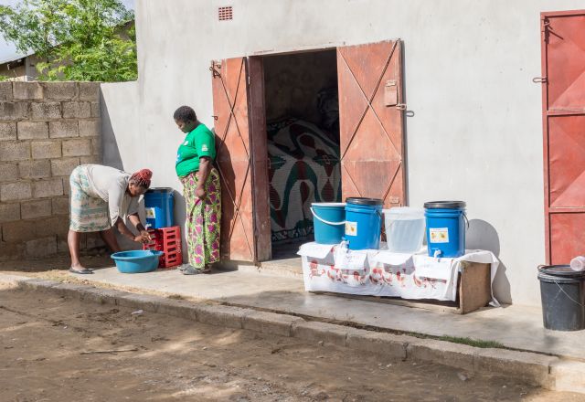 Lindah Lungu and Alice Tembo, washing her hands at an Oral Rehydration Treating Point (ORTP) Center set up by Oxfam partner, Keepers Zambia Foundation during a cholera outbreak