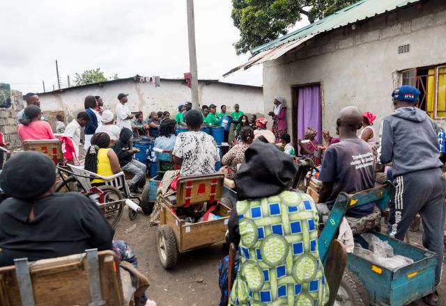group of people waiting waiting to receive Non-food items (NFIs) from Oxfam partners
