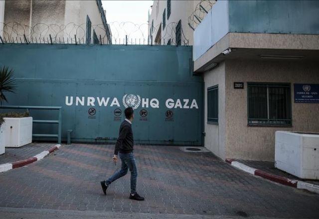 Picture of UNRWA HQ's gate in Gaza. A person was walking by when the picture was taken.