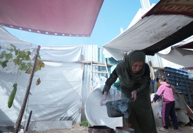 Woman cooking in manmade shelter on the West Bank.