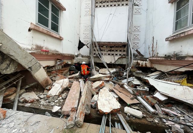 Rescuers search for survivors in damaged government staff housing buildings following an earthquake in Naypyidaw.