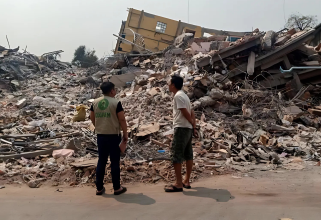 2 person looking at rubbles after the Myanmar earthquake. 
