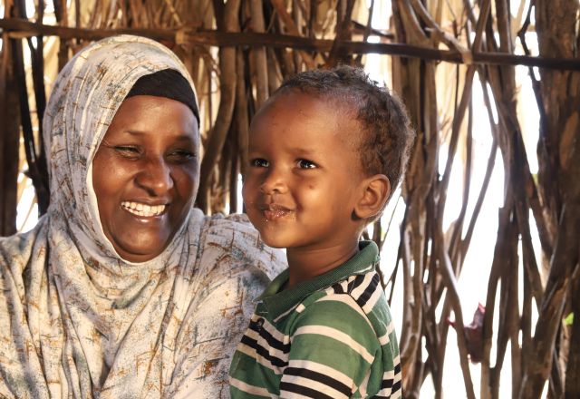 Abdia Ibrahim, program participant of the water project in Barambale in Isiolo county where a water point was set up by MID -P in partnership with Oxfam drinks tea with her son.