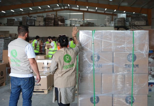 Loading and packing a shipment of dry food parcels from Oxfam that was prepared for delivery.