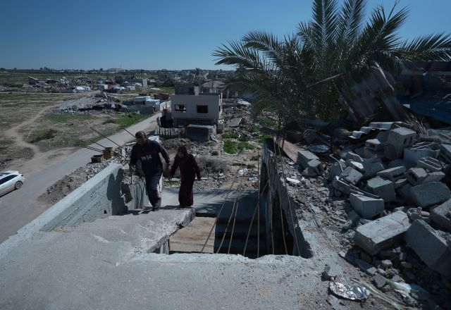 Suhad and her husband walking in the rubbles of their old house.