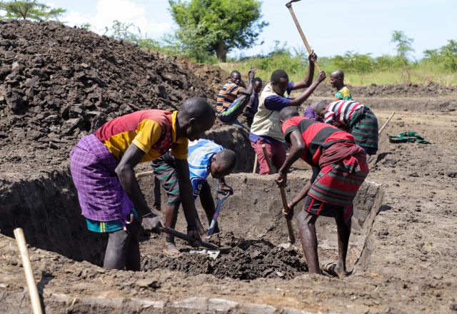 Farmers in Uganda working on a water pond