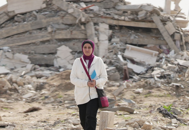 woman walking through rubble in Gaza
