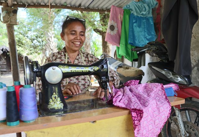 Agnes (age 46) sews a dress at her work space