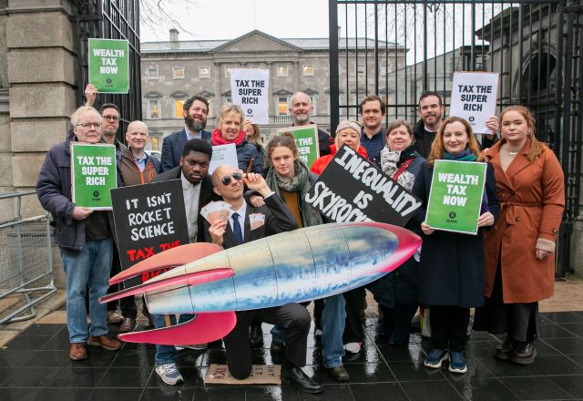 Oxfam Ireland tax the super rich stunt - campaigners, politicians and staff protesting outside Leinster House