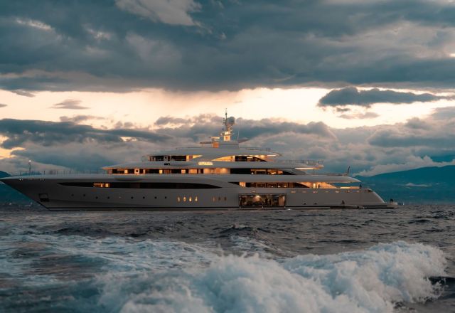 White billionaire superyacht on the sea with clouds behind it