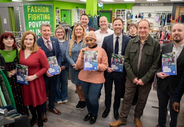 Oxfam staff in the Superstore shop in Holywood standing holding the GEM brochure