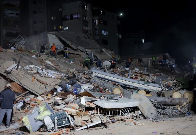 People and rescuers work on the debris from the Rita building after a magnitude 7.2 earthquake struck Venezuela and other regions in the Caribbean 