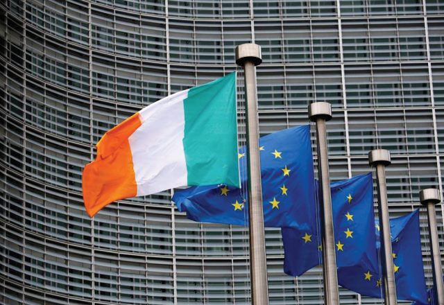 Irish flag beside three European Union flags.