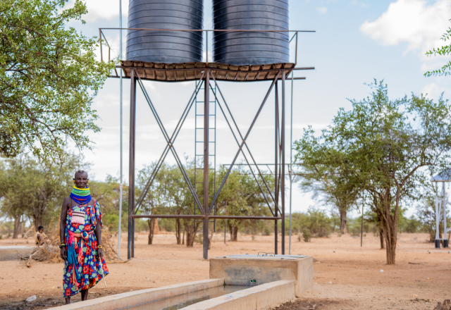 Monti Loibon standing next to Oxfam constructed water point.