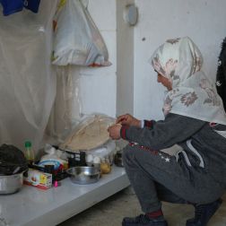 A displaced girl from Aleppo by the earthquake, makes a meal of boiled potatoes and bread