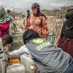 people with jerry cans at a distribution point built by Oxfam