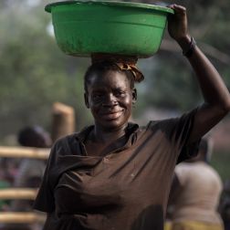 yvonne holds a bucket of drinkable water on her head