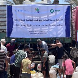 Group of displaced people trying to fill their jerrycans and buckets with water.