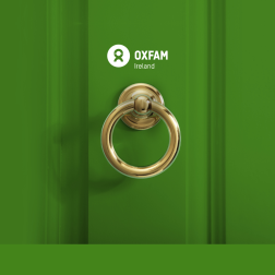 Door knob with Oxfam Ireland' logo above it. The door is green.