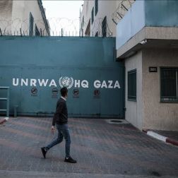 Picture of UNRWA HQ's gate in Gaza. A person was walking by when the picture was taken.