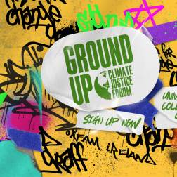 A graffiti wall with a sticker in the middle with the Ground Up Climate Justice Forum logo and stickers saying Sign Up Now and University College Cork