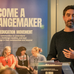 Dr Brendan Browne speaking in a podium in an event in Belfast