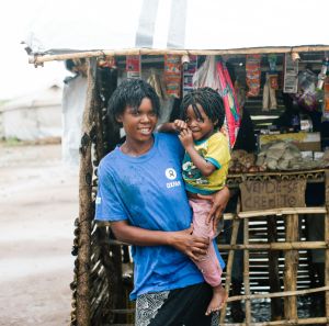 Sonia, and her child in front of her business