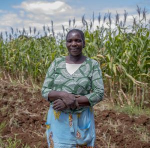 Sarah, a farmer in front of maize crops
