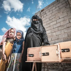 Nazrah Mohsen with her daughters and beehives