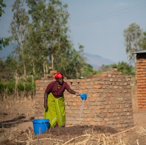 Ligineti Nayinayi a Cyclone Freddy Survivor is seen watering mud for making bricks at her village in Phalombe southern Malawi