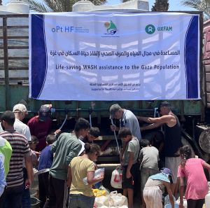Group of displaced people trying to fill their jerrycans and buckets with water.