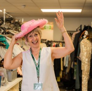 Barbara, a volunteer at Oxfam Holywood Superstore, having fun trying fancy hat.