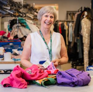 Barbara, a volunteer at Oxfam Holywood Superstore, sorting new donations.