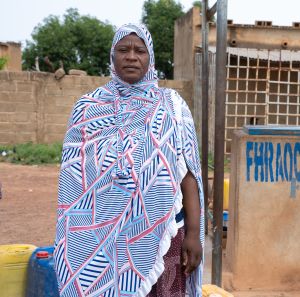 Adjaratou Sawadogo stands beside a water facility built by Oxfam in Boulsa, Burkina Faso.