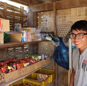 Chansouk standing in front of his shop's shelves