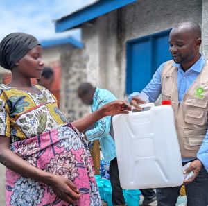 Muhawe Myriam Charmante receiving Non-Food Item kits from Oxfam staff.