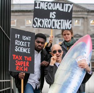Stunt organised by Oxfam Ireland for the launch of their Wealth Inequality report. One of the sign reads "Inequality is skyrocketing" beside a man playing a billionaire look alike.